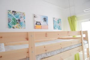 a wooden bunk bed in a room with paintings on the wall at Enjoy Sevilla Familia in Seville