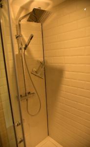 La salle de bains est pourvue d'une douche avec une porte en verre. dans l'établissement La Tête Dans Les Étoiles, à Boeschèpe