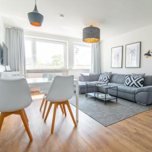 ein Wohnzimmer mit einem Sofa, einem Tisch und Stühlen in der Unterkunft StayS Apartments in Nürnberg