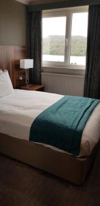 a bed in a hotel room with a window at Beech Hill Hotel & Spa in Windermere