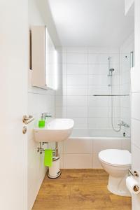 Un baño blanco con lavabo e inodoro. en StayS Apartments, en Núremberg 19 fotos más