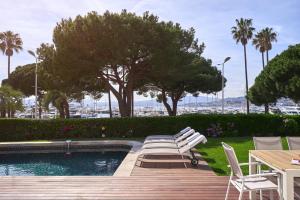 - une piscine avec des chaises, une table et des arbres dans l'établissement FRGK"Contemporary Villa on the Croisette with Stunning Sea Views & Private Pool!!!, à Cannes