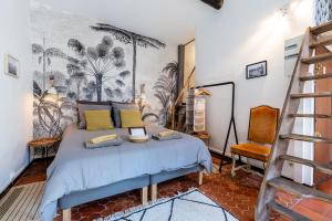 ein Schlafzimmer mit einem Bett und einem Stuhl darin in der Unterkunft LE PANIER ENCHANTÉ - Suites & Loft - Terrasse et patio au dessus du Vieux Port in Marseille