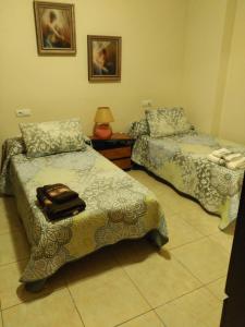 Habitación con 2 camas y mesa con lámpara. en Como en casa, en Alicante