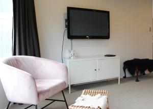 un soggiorno con sedia e TV a parete di 33 - Location location, right amongst it a Wanaka