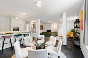 cocina y sala de estar con mesa de cristal y sillas en Classy Apartment in City Center with Large Balcony, en Gante