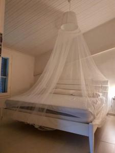 リド・ディ・ヴォラーノにあるHoliday Home Resyのベッドルーム(蚊帳付きのベッド付)