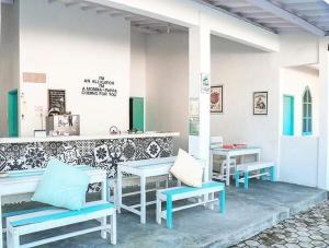 a restaurant with benches and tables and a counter at Boogie Hostel Kuta Lombok in Kuta Lombok
