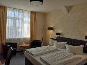 ein Hotelzimmer mit einem Bett und einem Fenster in der Unterkunft Hotel Zur Alten Druckerei in Gotha