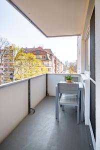 Un balcón con una mesa y vista a una ciudad. en StayS Apartments, en Núremberg