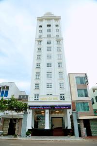 un edificio blanco alto con un cartel delante en Thanh Van Hotel Quy Nhon, en Quy Nhon