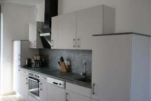 uma cozinha com armários brancos e um lavatório em Ferienwohnung Weinbergblick em Mehring