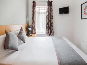 Un dormitorio con una cama grande y una ventana en OYO London Guest House, en Londres