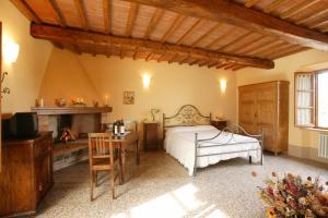sypialnia z łóżkiem, stołem i kominkiem w obiekcie Agriturismo Podere San Gregorio w mieście Pienza
