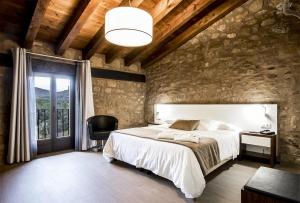 ein Schlafzimmer mit einem großen weißen Bett und einem Stuhl in der Unterkunft Hotel Restaurante Masía la Torre in Mora de Rubielos
