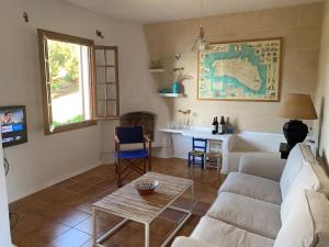 a living room with a couch and a table at Casa con jardin ,vistas al mar y atardecer en Playas de Fornells in Es Mercadal