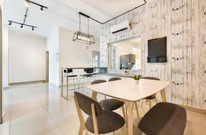 a dining room with a wooden wall with a table and chairs at Seasons Luxury Apartment By RR JBcity in Johor Bahru