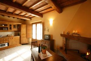 a kitchen with a wooden table and a fireplace at Agriturismo Podere San Gregorio in Pienza