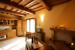 uma cozinha com uma mesa de madeira e uma lareira em Agriturismo Podere San Gregorio em Pienza