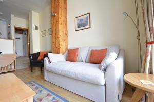 uma sala de estar com um sofá branco e uma mesa em Old Town View - Picture Perfect! em Edimburgo
