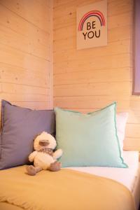 a teddy bear sitting on a bed next to a pillow at Sielankownia in Wünschelburg