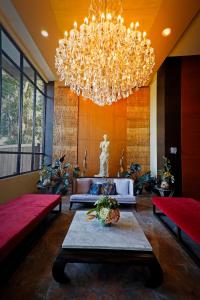 un gran vestíbulo con una gran lámpara de araña y una mesa en Venus Parkview Hotel en Baguio