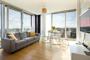 ミルトン・キーンズにある2 Bedroom 2 Bathroom Apartment in Central Milton Keynes with Free Parking and Smart TV - Contractors, Relocation, Business Travellersのリビングルーム(ソファ、テーブル、椅子付)