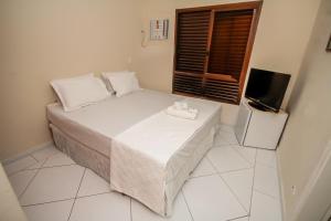 Ένα ή περισσότερα κρεβάτια σε δωμάτιο στο Suites Natalia Enseada