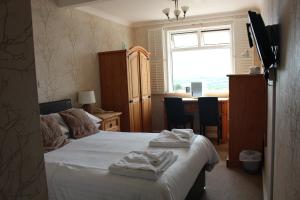 a bedroom with a bed with towels on it at The Moorland Hotel in Wotter