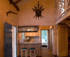 una cocina con dos taburetes y un reloj en la pared en Casa Vacacional Rural Villa Barranco de los Cernícalos, en Valsequillo