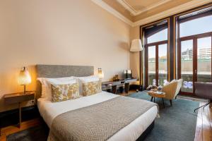 a hotel room with a bed and a desk and window at YOUROPO - Bolhao in Porto