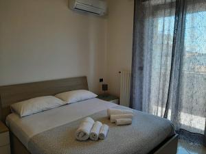 a bedroom with a bed with two towels on it at DOMUS MARIS Viserba, Speciale offerta di Pasqua,Spiagge e Centro a 100 mt, a 5 minuti RIMINIFIERA Offerta THE COACH EXPERIENCE GINNASTICA IN FESTA RIMINI 2024 in Rimini