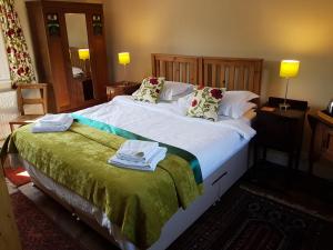 a bedroom with a large bed with towels on it at Oak Tree Farm in Yoxford