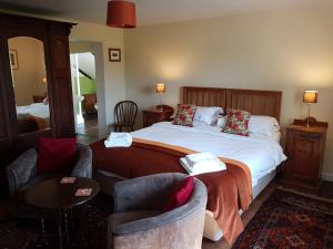 a hotel room with a bed and two chairs at Oak Tree Farm in Yoxford