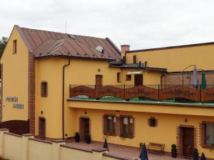 - un bâtiment jaune avec un balcon au-dessus dans l'établissement Penzion Anesis - štúdiá, à Turčianske Teplice