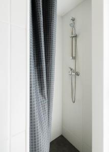 La salle de bains est pourvue d'une douche avec rideau de douche. dans l'établissement Baixa24 •P1L• Amplo estúdio na baixa com varanda, à Porto