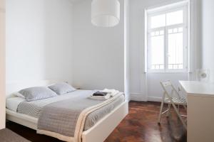 a white bedroom with a bed and a table at Baixa24 · City Center Private Sun Deck Apartment in Porto