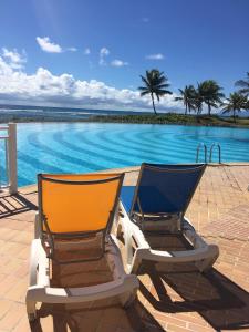 2 sillas sentadas junto a una piscina en STUDIO TIPUNCH, en Saint-François