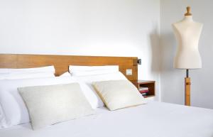 a white bed with white pillows and a lamp at FuordArno Bed & Breakfast in Florence