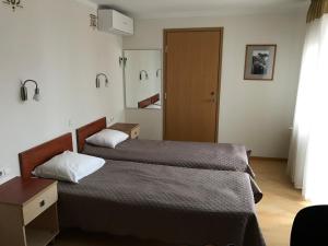 a bedroom with a bed and a wooden door at Hommiku Guesthouse in Pärnu