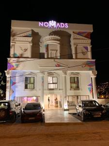 a large white building with cars parked in front of it at Nomads Hotel Petra in Wadi Musa
