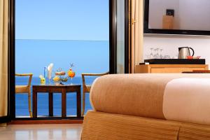 a bedroom with a bed and a table with a view at Alberi del Paradiso in Cefalù