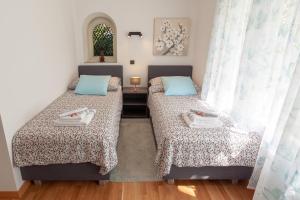 two twin beds in a room with a window at Villa Magnolia in Ljubljana