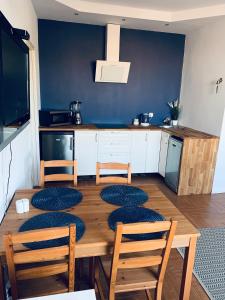 Una mesa de comedor con sillas y una cocina. en Apartament Il Capitano, en Gdynia 14 fotos más