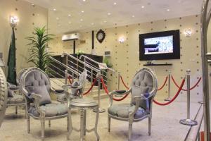 a waiting room with two chairs and a tv at Dar Al Jood Hotel units in Qal'at Bishah