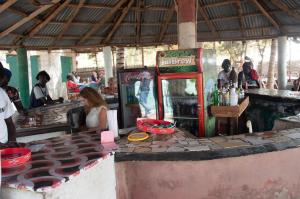 a woman sitting at a counter in a restaurant at Rainbow beach resort in Sanyang