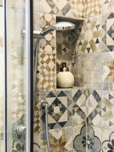 a shower in a bathroom with a tile wall at B&B Opera dei Pupi in Palermo