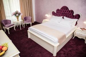 um quarto com uma cama grande e uma cabeceira vermelha em Royal Boutique Mangalia Breeze em Mangalia