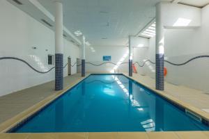 a swimming pool with blue water in a building at Les Cimes Du Val D'Allos in La Foux