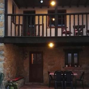 a balcony of a house with a table and chairs at Casalacapillajelgueres in Cangas de Onís